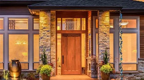 A front door of a house with flowers in the window.