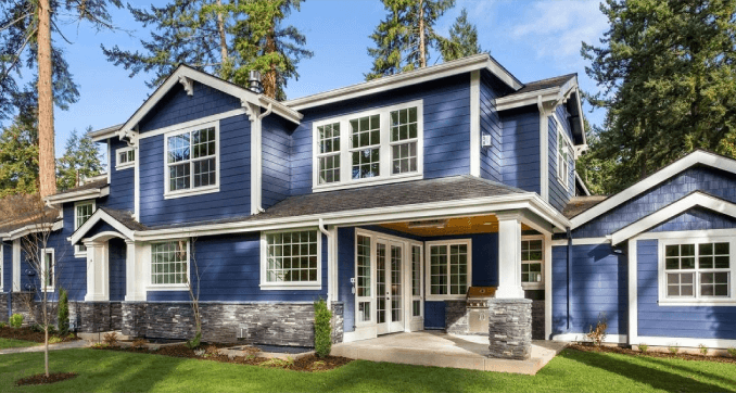 A blue house with white trim and stone pillars.