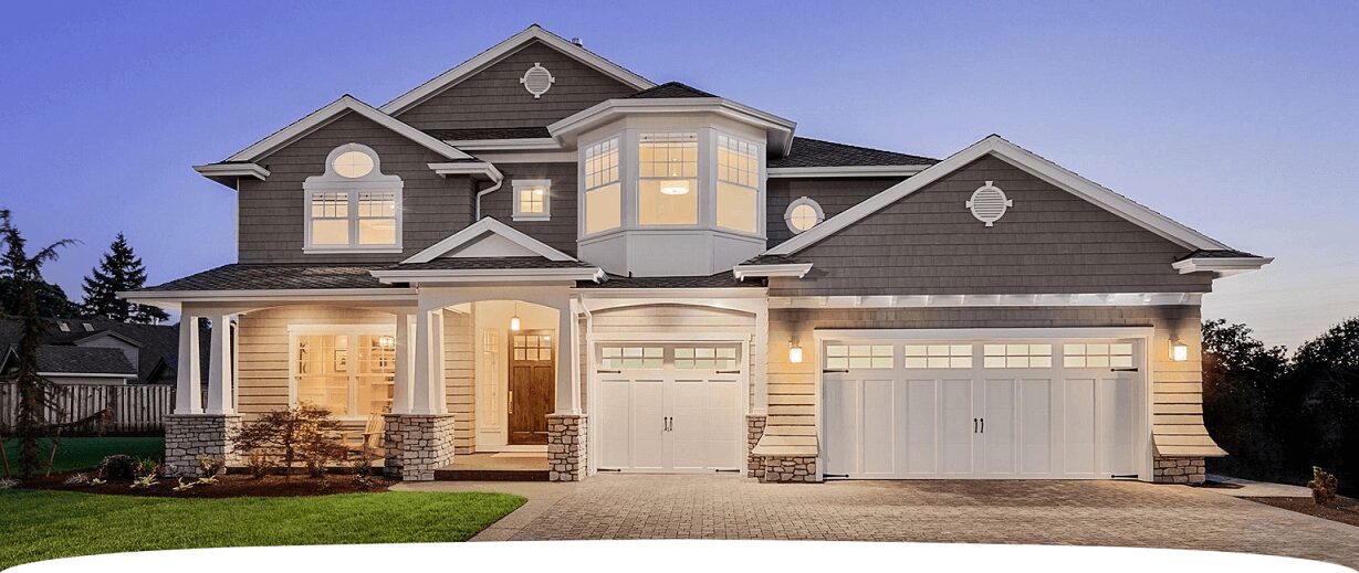 A large house with two garage doors and a driveway.