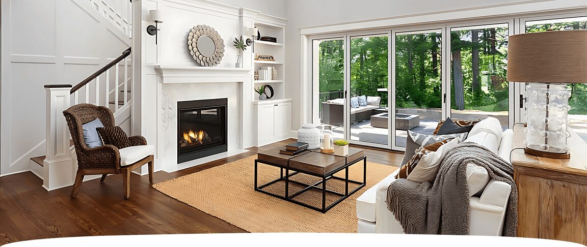 A living room with a fireplace and a large window.